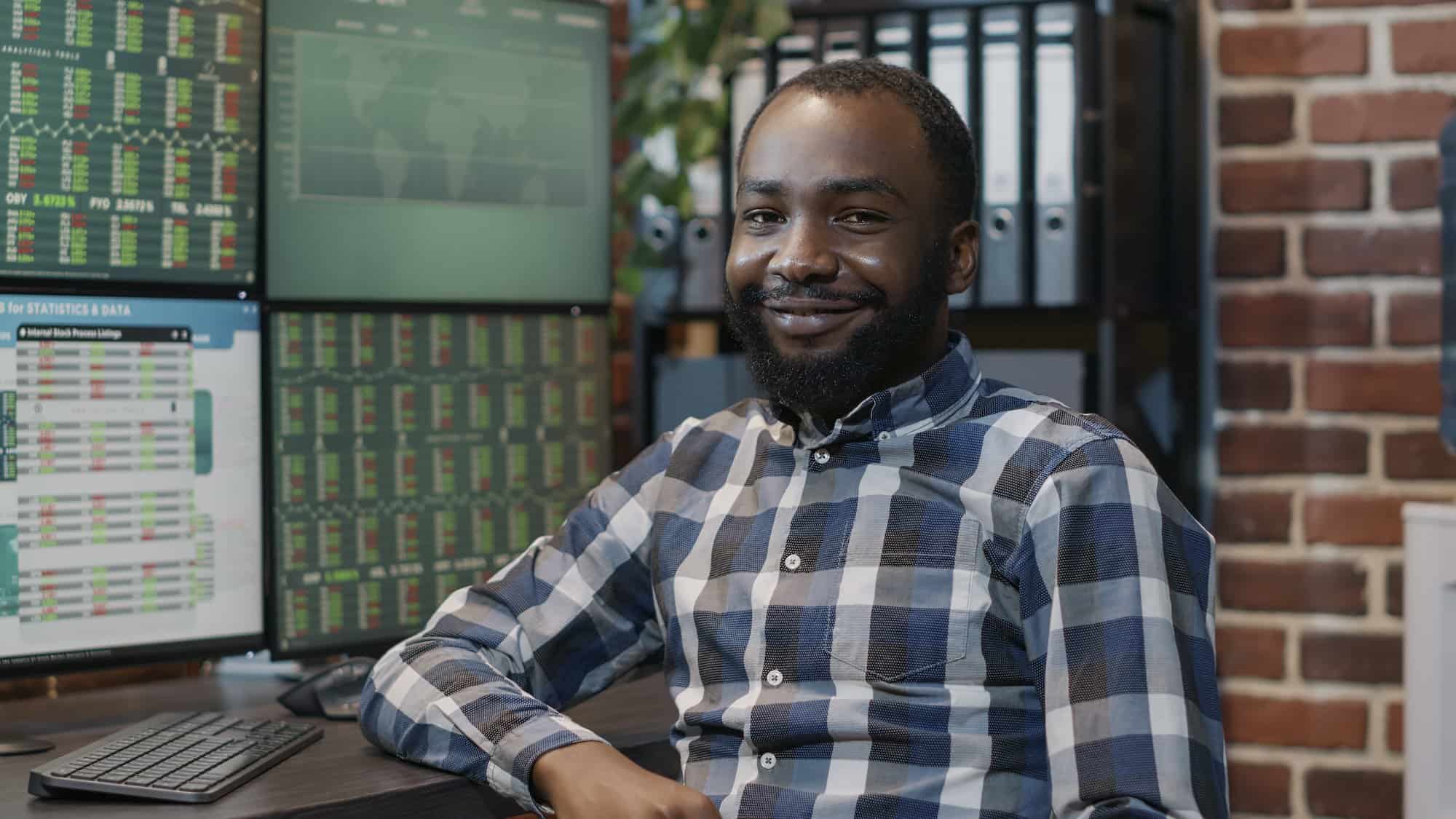 Portrait of african american man using multi monitors to work